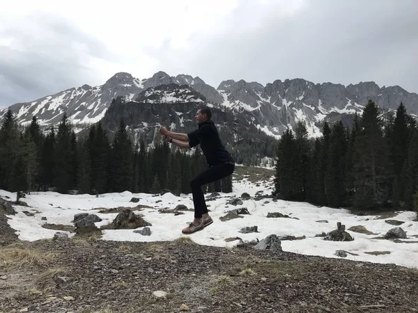 Vista Trasera Del Viajero Masculino Saltando Entre Montañas Nevadas Cubiertas — Foto de Stock