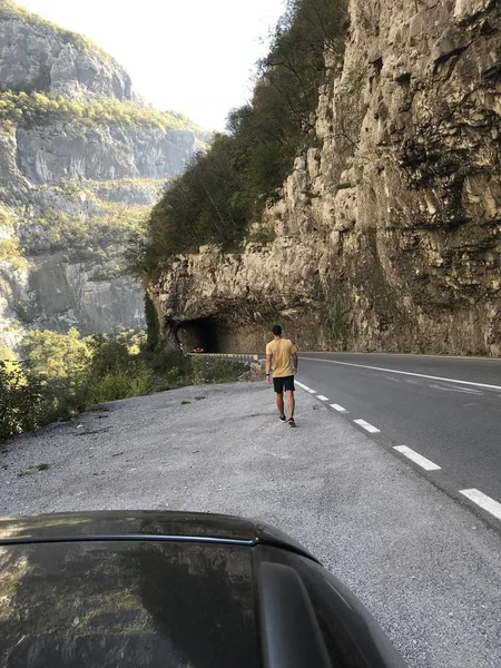 Vista Trasera Del Hombre Caminando Por Camino Vacío Entre Altas — Foto de Stock