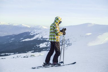 Kış dağlarında tepede duran özel kayak ekipmanları olan bir adam. 