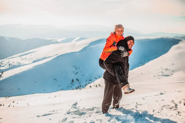 Man Giving Woman Piggyback Ride Hill Winter Mountains Sunny Day — Stock Photo, Image