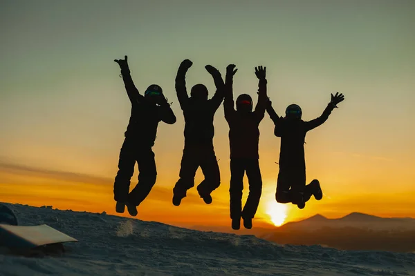 Siluetas Amigos Ropa Invierno Saltando Juntos Colina Las Montañas Invierno — Foto de Stock