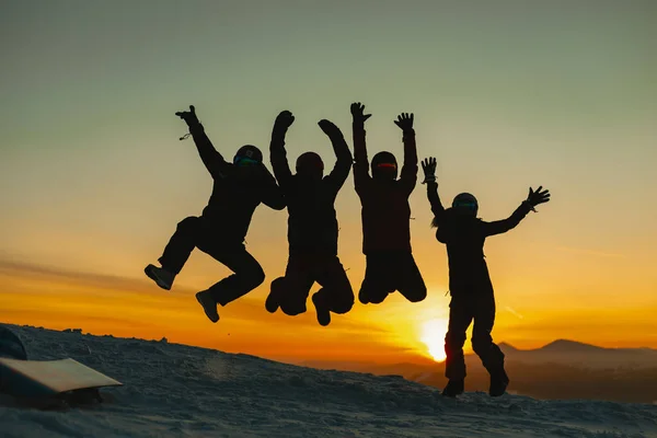 Siluetas Amigos Ropa Invierno Saltando Juntos Colina Las Montañas Invierno — Foto de Stock
