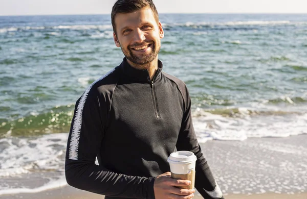 Bonito Homem Sportswear Com Papel Xícara Café Praia — Fotografia de Stock