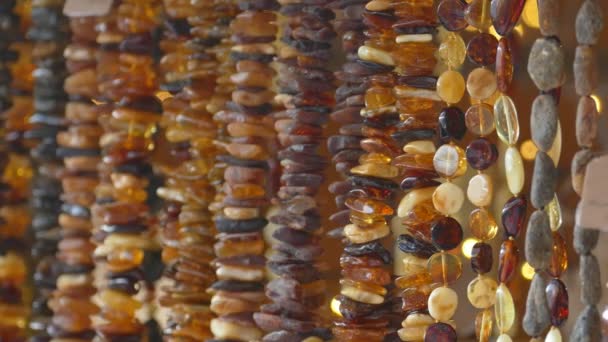 Jantarový náhrdelník zavěšený na stojanu se suvenýry — Stock video