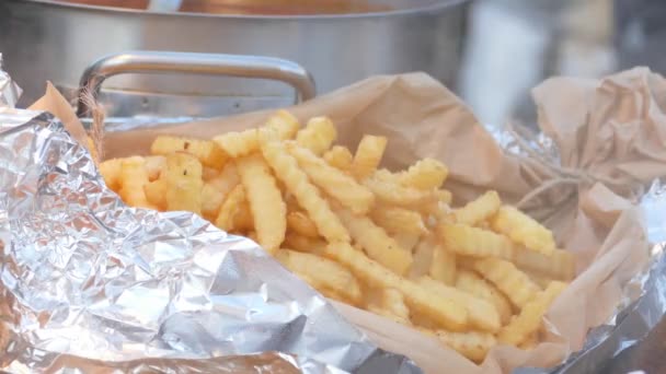 Papas fritas envueltas en papel de aluminio en el puesto de comida del mercado — Vídeo de stock