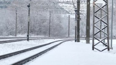 Banliyö yolcu treni karlı kış gününde kalkıyor.