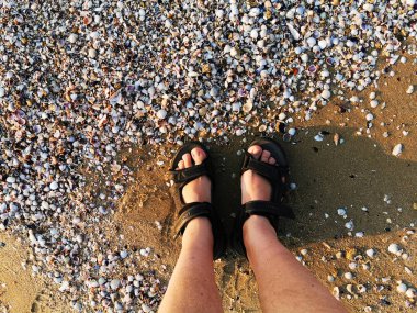 Sahilde sandalet içinde ayaklar