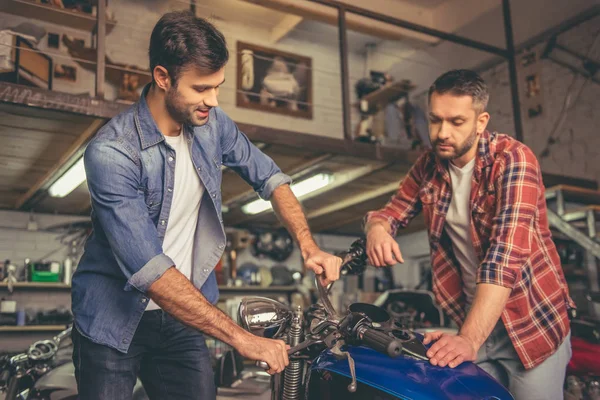 Rapazes na oficina de reparação de motos — Fotografia de Stock