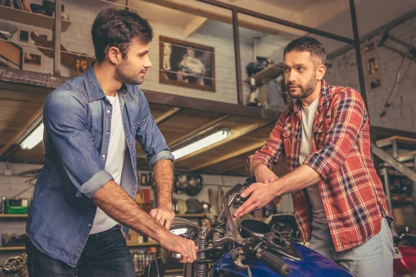 Rapazes na oficina de reparação de motos — Fotografia de Stock