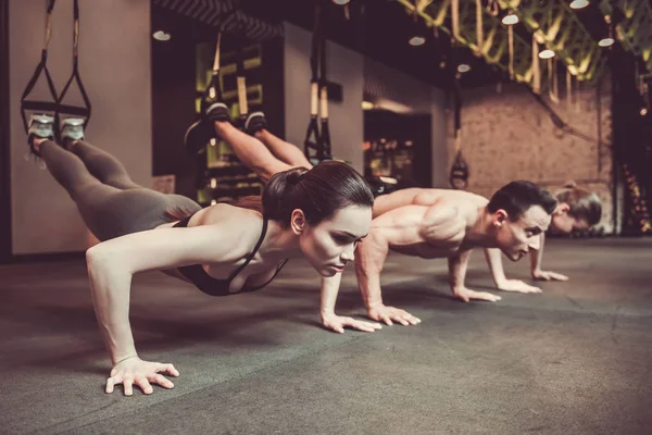 Jovens trabalhando com TRX — Fotografia de Stock