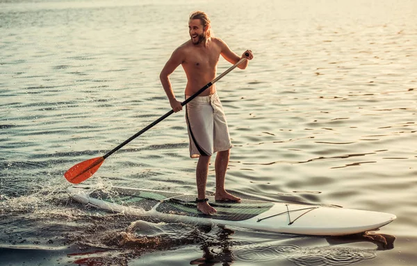 Man standup paddleboarding — Stockfoto