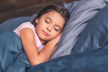 Küçük kız yatakta.