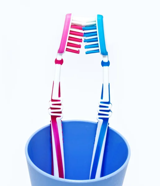 Two toothbrushes in glass on white — Stock Photo, Image