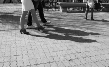 Şehrin sokaklarında ayakkabılar ve spor ayakkabılarla yürüyorum.