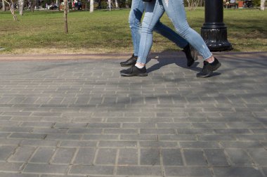 Şehrin sokaklarında ayakkabılar ve spor ayakkabılarla yürüyorum.