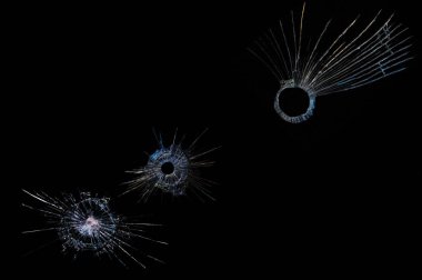 Kırık camlardaki siyah arka plandaki çatlaklar kurşun seslerinden kaynaklanıyor.