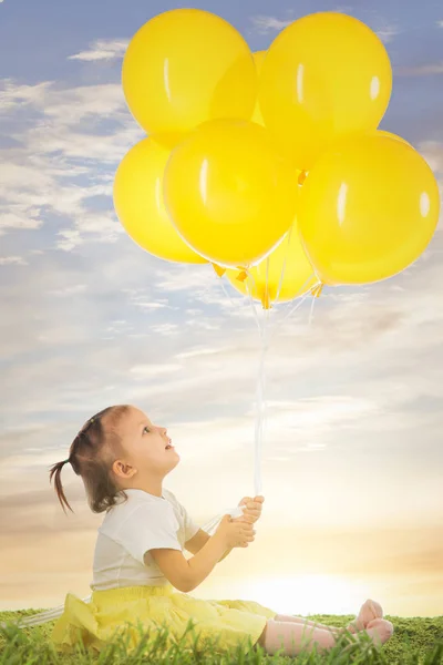 little girl with yellow balloons