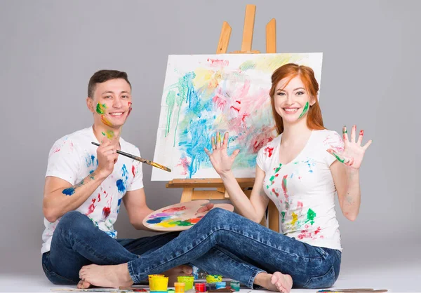 The guy and the girl draw paints