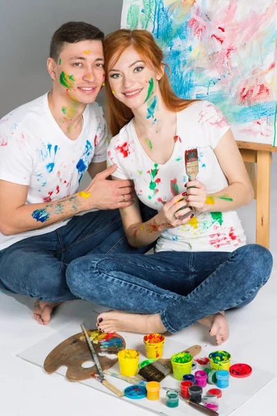 The guy and the girl draw paints