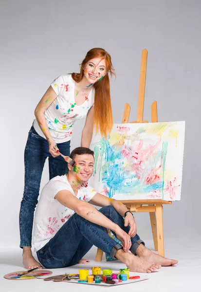 The guy and the girl draw paints