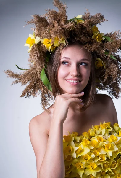 A young woman in a wreath of reeds and daffodils