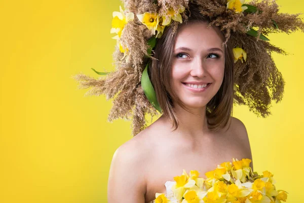 A young woman in a wreath of reeds and daffodils