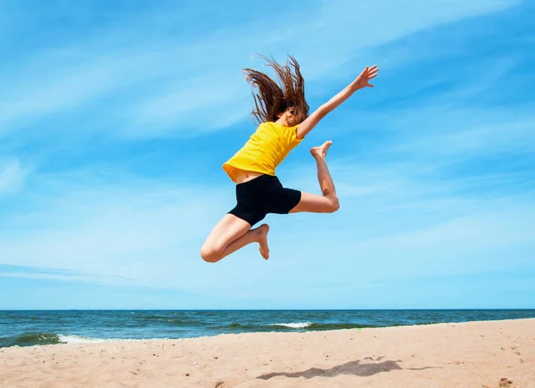 Heureuse fille active sautant à la plage — Photo