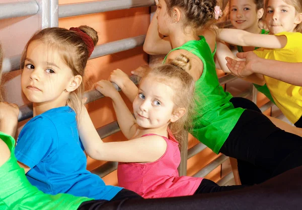 Маленькие гимнастки делают упражнения в спортзале — стоковое фото