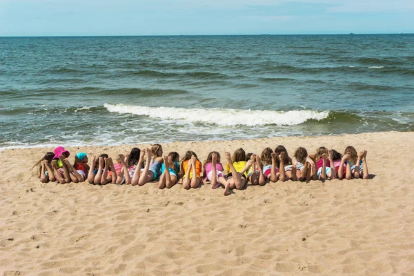 Grupa dzieci leżąc na plaży — Zdjęcie stockowe