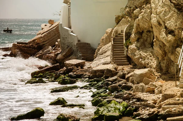 Een ladder in de rots die leidt tot de woeste zee. — Stockfoto