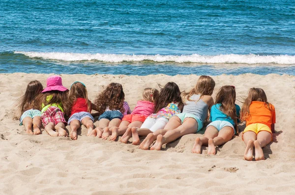 Gruppo di bambini sdraiati sulla spiaggia — Foto Stock