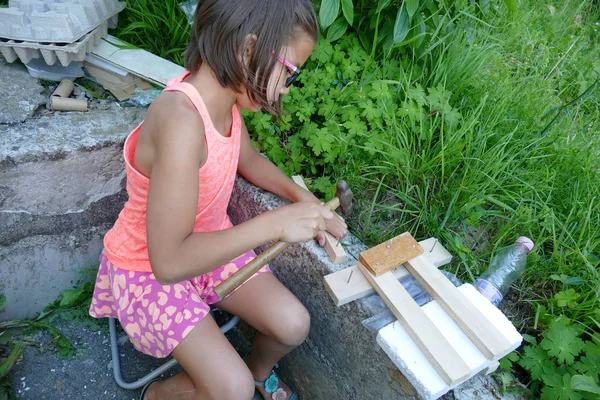 Una chica realiza un proyecto de madera . Imagen de stock