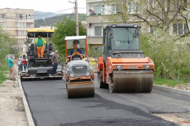 Gabrovo, Bulgaristan 13 Nisan 2018 sokak Asphalting. Makine asfalt yatıyor. İki merdane asfalt pürüzsüz.