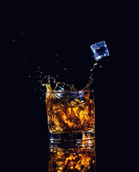 Geïsoleerde schot van whisky met splash op zwarte achtergrond, brandy — Stockfoto