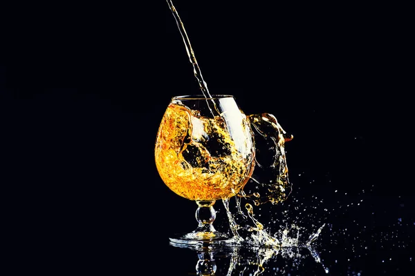 Glas Med Cognac Med Stänk Svart Bakgrund — Stockfoto