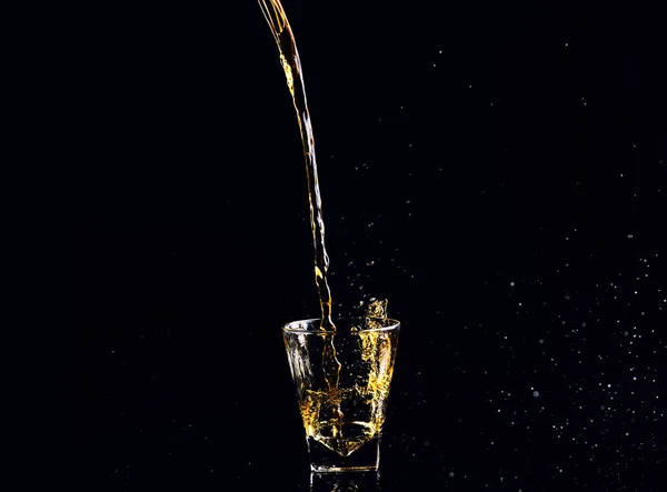 黑色背景飞溅的威士忌 在玻璃杯白兰地的孤立拍摄 — 图库照片