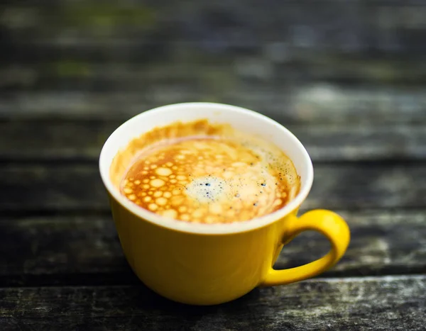 Eine Gelbe Tasse Leckeren Kaffee Auf Rustikalem Holztischhintergrund — Stockfoto