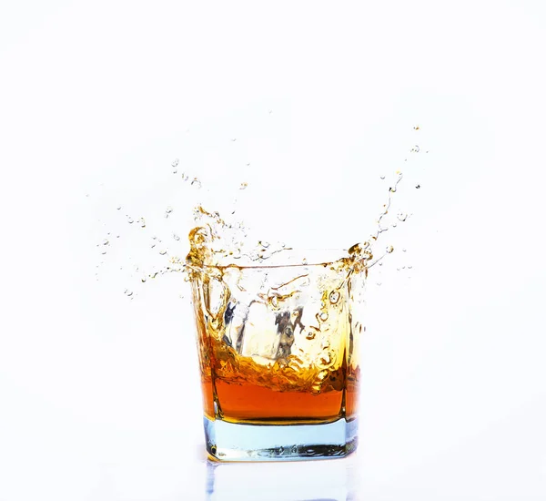 Strzał na białym tle whisky z splash na białym tle, brandy — Zdjęcie stockowe