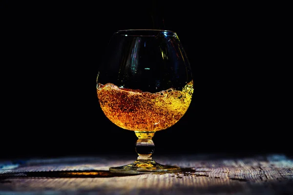 Verre avec cognac sur fond bois — Photo