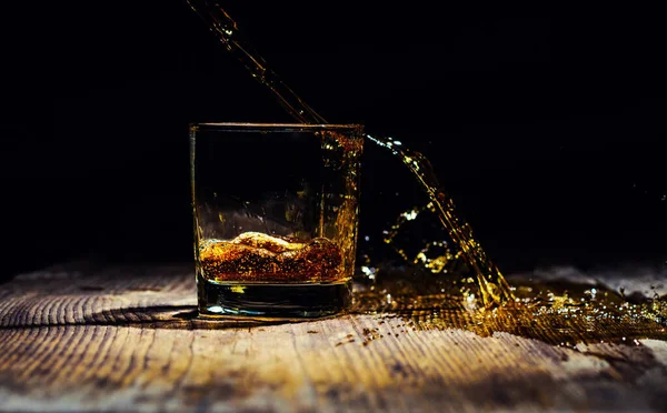 Geïsoleerde shot whisky met splash op zwarte achtergrond — Stockfoto