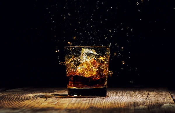 Isolierter Schuss Whisky mit Spritzer auf schwarzem Hintergrund — Stockfoto