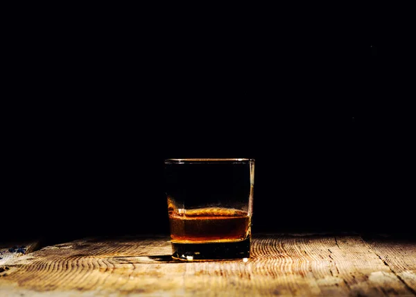 Isolated shot of whiskey with splash on black background — Stock Photo, Image