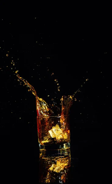 Geïsoleerde shot whisky met splash op zwarte achtergrond — Stockfoto