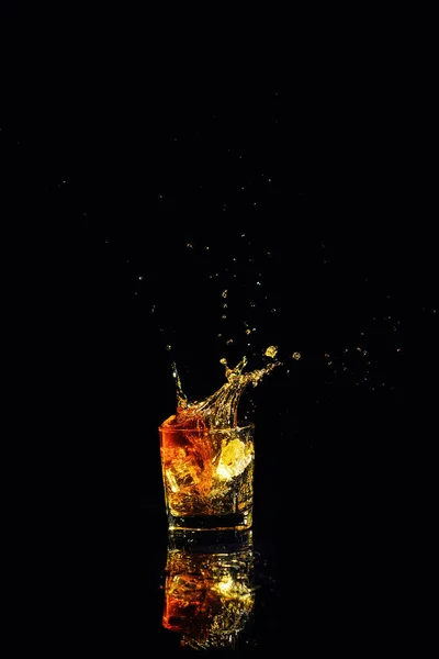 Colpo isolato di whisky con spruzzata su sfondo nero — Foto Stock