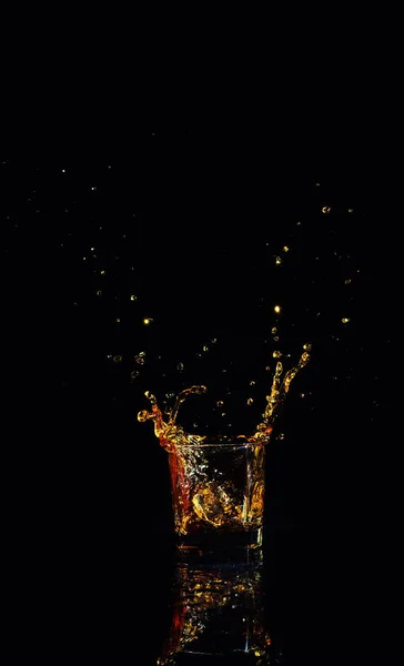 Isolated shot of whiskey with splash on black background — Stock Photo, Image