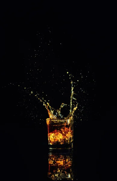 Isolated shot of whiskey with splash on black background — Stock Photo, Image