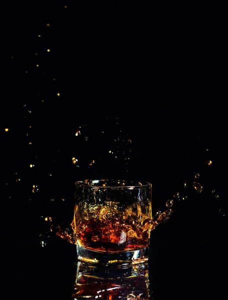 Isolerad bild av whisky med stänk på svart bakgrund — Stockfoto