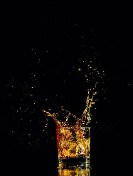 Isolierter Schuss Whisky mit Spritzer auf schwarzem Hintergrund — Stockfoto