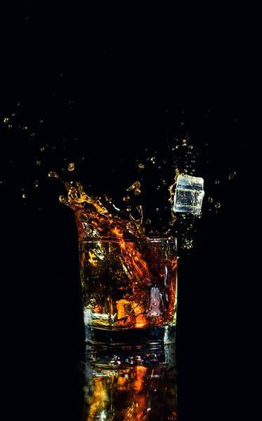 Colpo isolato di whisky con spruzzata su sfondo nero — Foto Stock