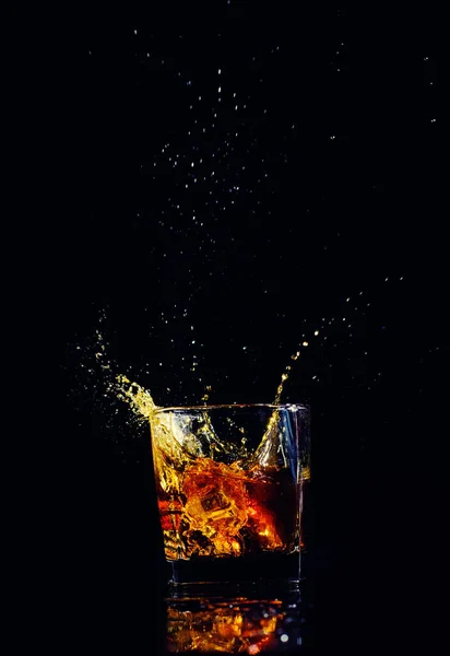 Isolierte Aufnahme von Whisky mit Spritzer auf schwarzem Hintergrund, Brandy — Stockfoto
